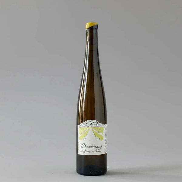 A dark brown glass bottle of Chardonnay from Grangeon de L'ALbarine, featuring a white label with a yellow sunburst graphic and a yellow capsule seal at the top, set against a light gray marble background.
