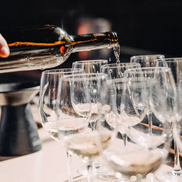 Wine being poured into tasting glasses at Cave
