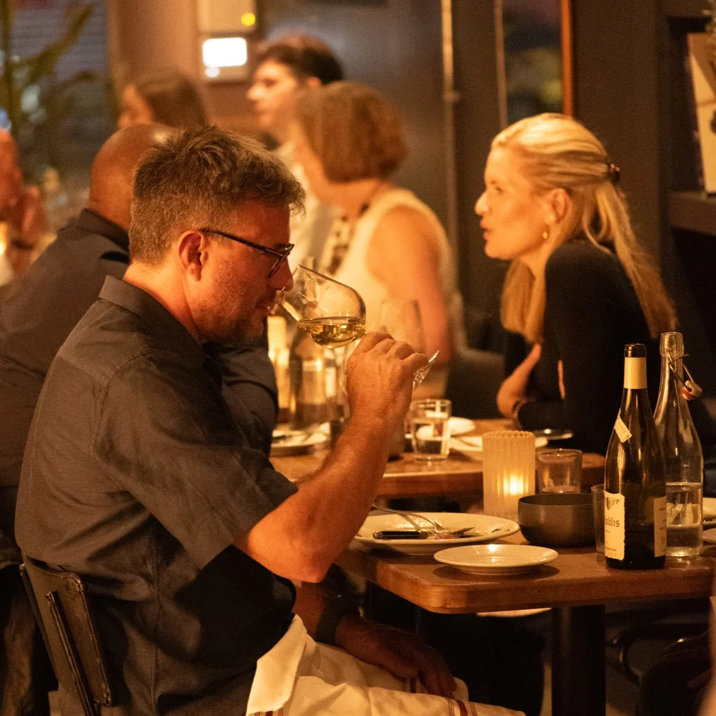 Guests enjoying wine and dinner at Cave