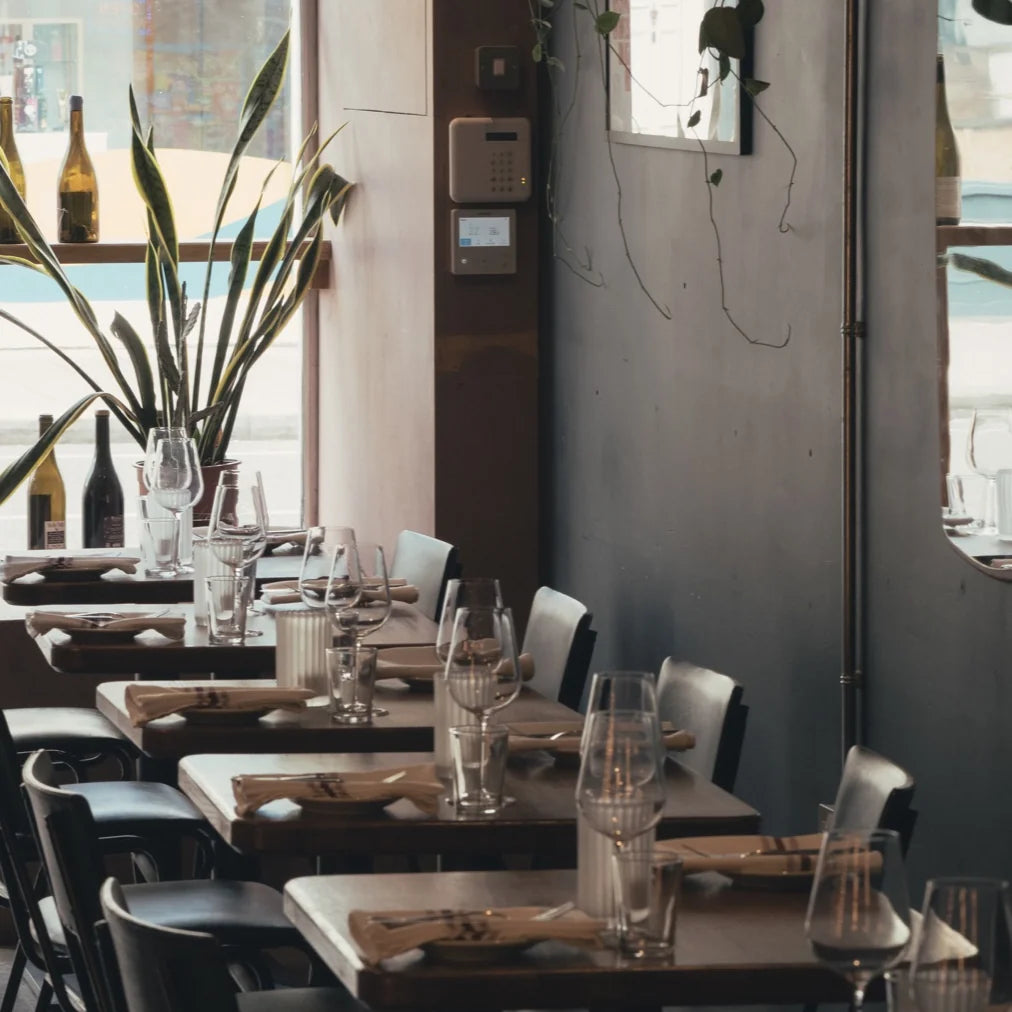 Sunlight falling across the tables and wine glasses at Cave