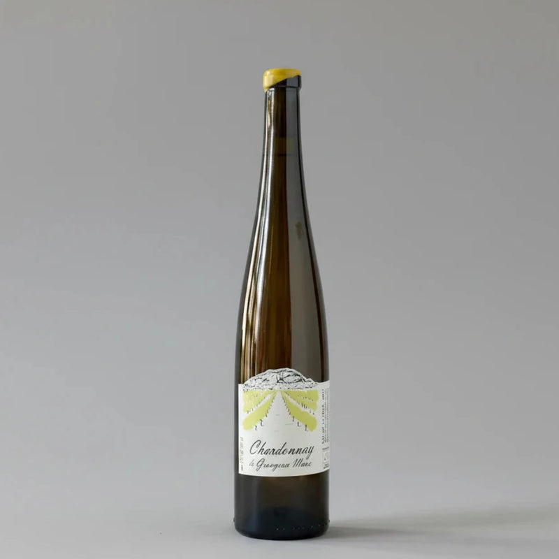 A dark brown glass bottle of Chardonnay from Grangeon de L'ALbarine, featuring a white label with a yellow sunburst graphic and a yellow capsule seal at the top, set against a light gray marble background.